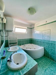 La salle de bains est pourvue de 2 lavabos et d'une baignoire. dans l'établissement Apartments Valbandon, à Fažana