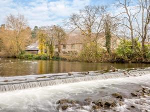 a river with a waterfall in front of a building at 3 Bed in Bakewell 90579 in Bakewell
