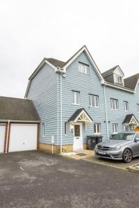 a large blue house with a car parked in front of it at Spacious and Luxurious 5 Bedroom Town House for 9 in Kent