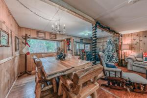 une salle à manger avec une table en bois et un arbre de Noël dans l'établissement Happy Home, à Ruidoso
