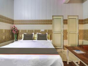 a bedroom with a large bed and a table at Collection O Hotel Paradise And Restaurant in Kāshīpur