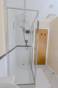 a glass shower in a bathroom with a door at Spacious and Luxurious 5 Bedroom Town House for 9 in Kent