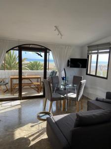 a living room with a couch and a table and chairs at Villa Tiki Apartment Audrey in Playa Jandia