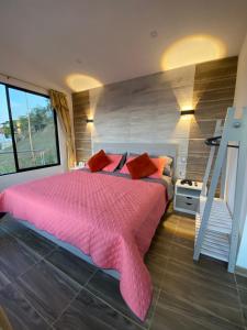 Un dormitorio con una gran cama rosa y una escalera en Esmeralda DELUXE, en San Gil