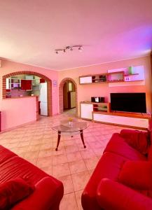 - un salon avec un canapé rouge et une table dans l'établissement Apartments Valbandon, à Fažana