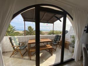 a room with a table and chairs on a balcony at Villa Tiki Apartment Audrey in Playa Jandia