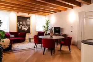 a living room with a table and red chairs at Palazzo Reggiani - Leonardo Da Vinci in Verona