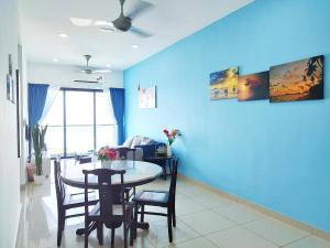 uma sala de jantar com uma mesa e uma parede azul em PuchongIsland WindyStay3R2B8Pax AT D'Island em Puchong