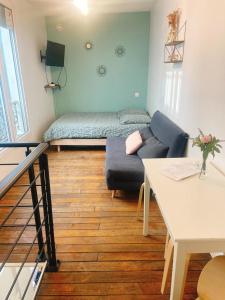 ein Wohnzimmer mit einem Sofa und einem Bett in der Unterkunft Duplex Atypique Paris 13 Station F Bercy in Paris