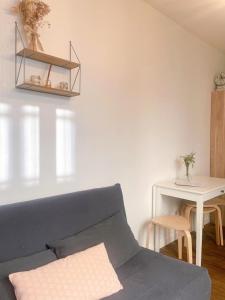 Una sala de estar con un sofá azul y una mesa. en Duplex Atypique Paris 13 Station F Bercy, en París