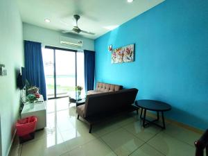 uma sala de estar com um sofá e uma parede azul em PuchongIsland WindyStay3R2B8Pax AT D'Island em Puchong