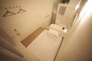 Blanc Inn في سنغافورة: حمام أبيض صغير مع حوض ومرحاض