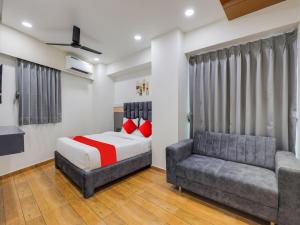 a bedroom with a bed and a couch at OYO 82103 Hotel Galaxy in Surat