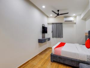 a bedroom with a bed and a flat screen tv at OYO 82103 Hotel Galaxy in Surat