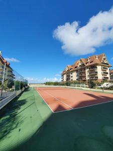 a tennis court in front of some apartment buildings at Studio cocooning petite vue mer in Cabourg