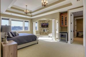 a large bedroom with a bed and a fireplace at Luxury 7400 sq.ft Stunning Home Theater/Sleeps 18+ in Plymouth +56 photos