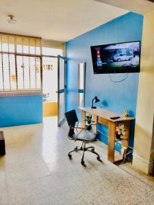 Cette chambre dispose d'un bureau, d'une chaise et d'une télévision. dans l'établissement Habitación en Chiclayo, à Chiclayo