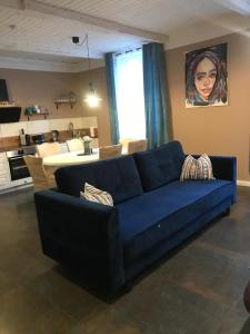 a living room with a blue couch and a kitchen at Moderne, stilvolle Ferienwohnung in Stralsund 84m2 in Stralsund