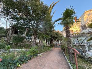 a brick path with trees and a building at Opatija Rooms & Apartments Semić - Free Parking and Sea View in Opatija +24 photos
