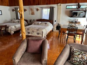 um quarto com 2 camas, uma mesa e cadeiras em Casa Haydee Monteverde em Monteverde