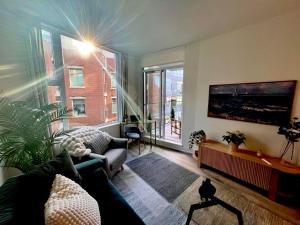 a living room with a couch and a large window at Stylish One Bedroom Retreat, Downtown Victoria, Fitness Room, Incredible Location! in Victoria