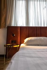 a bedroom with a large bed with a wooden headboard at Hotel National in Zagreb