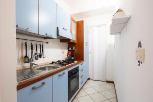 una cocina con armarios blancos y fregadero en Casa vacanze da Nina en Sanremo