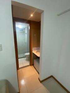 a bathroom with a toilet and a sink and a mirror at Quarto c/Ar, sala, cozinha, banheiro, garagem 24h. in Salvador