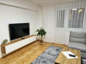 a living room with a flat screen tv and a couch at Apartment Urban Nest in Zenica