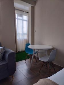 a living room with a table and two chairs and a couch at Cosy Studio Apartment in Nakuru.Lift.Wifi.Ample Parking in Nakuru