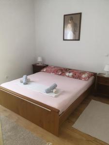 ein Schlafzimmer mit einem Bett mit weißer Bettwäsche und einem Bild an der Wand in der Unterkunft House Garden House in Kaštela