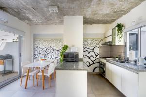 cocina con armarios blancos, mesa y sillas en Fliphaus Ravignani 1300 - 1 Bd Pool & Bbq en Buenos Aires