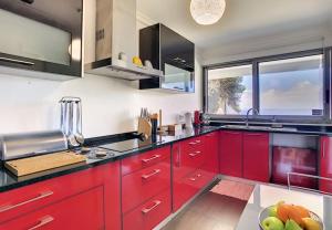 a kitchen with red cabinets and a large window at Villa Calçada in Santa Cruz