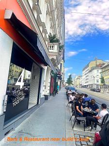 un grupo de personas sentadas en las mesas fuera de un restaurante en Ottakringer Paradise, en Viena
