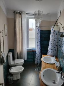 bagno con 2 lavandini, servizi igienici e finestra di Moderne, stilvolle Ferienwohnung in Stralsund 84m2 a Stralsund