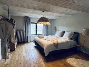 a bedroom with a large bed and a large window at ZEN Op Vakantie @vakantiehoeve met zwembad in Lierde