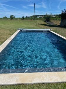 einen Pool mit blauem Wasser im Hof in der Unterkunft Maison de charme avec piscine in Orches