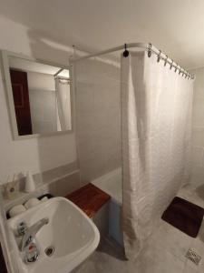 a white bathroom with a sink and a shower at Depto Tobas in Ushuaia