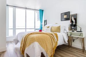 a bedroom with a bed with a yellow and white blanket at lovely 1-bedroom w/parking at Coal Harbour in Vancouver