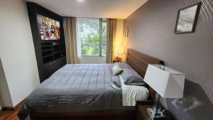 een kleine slaapkamer met een bed en een raam bij invitin annabella's apartment in Quito