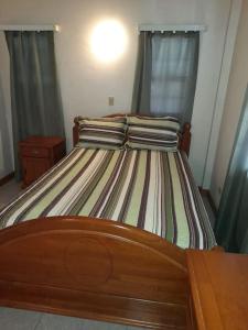 łóżko z prześcieradłami i poduszkami w sypialni w obiekcie Eden Place Apartments w mieście Saint Johnʼs