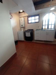 a kitchen with white cabinets and a large window at Depto Tobas in Ushuaia