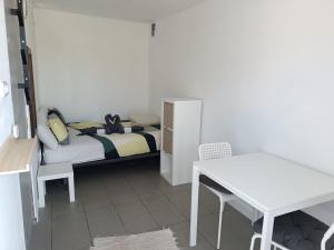 Camping Invernaderito في Tejina: غرفة نوم صغيرة مع سرير وطاولة