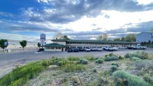 a building with cars parked in a parking lot at American inn in Elko