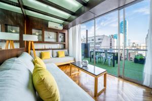 sala de estar con sofá y ventana grande en Fliphaus Santa Fe 800 - 1 Bd Terrace Pool Bbq en Buenos Aires