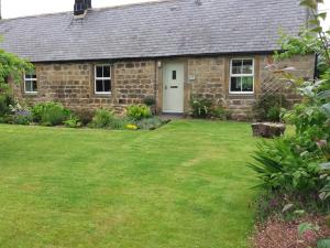 a stone house with a lawn in front of it at 2 Bed in Nr Amble CN049 in Acklington