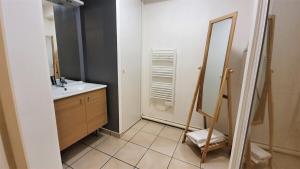 La salle de bains est pourvue d'un lavabo et d'un miroir. dans l'établissement Logement moderne et lumineux Terrasse et Parking, à Caen