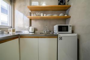 cocina con fregadero y nevera con microondas en Fliphaus Santa Fe 800 - 1 Bd Terrace Pool Bbq en Buenos Aires