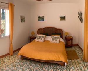 1 dormitorio con 1 cama con sábanas y almohadas de color naranja en Domaine des Lavarines, en Morières-lès-Avignon