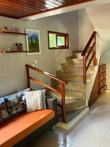 a living room with a staircase and a bench at Casa de praia pé na areia: nos braços da natureza. in Ilhéus